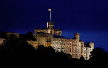 A view looking up at Windsor Castle, lit up in the dark